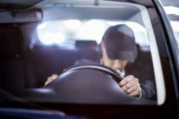 A man falls asleep while holding the steering wheel of his car because daylight savings time is connected to an increase in car accidents.