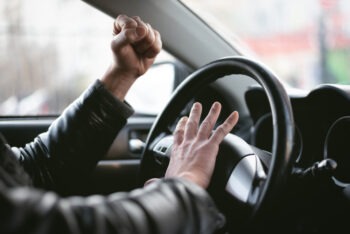 Conductor enojado toca claxon grita frente al volante agresion vial embotellamiento