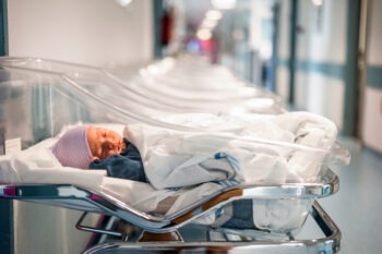 A baby in a small bed after a birth injury in Destin.